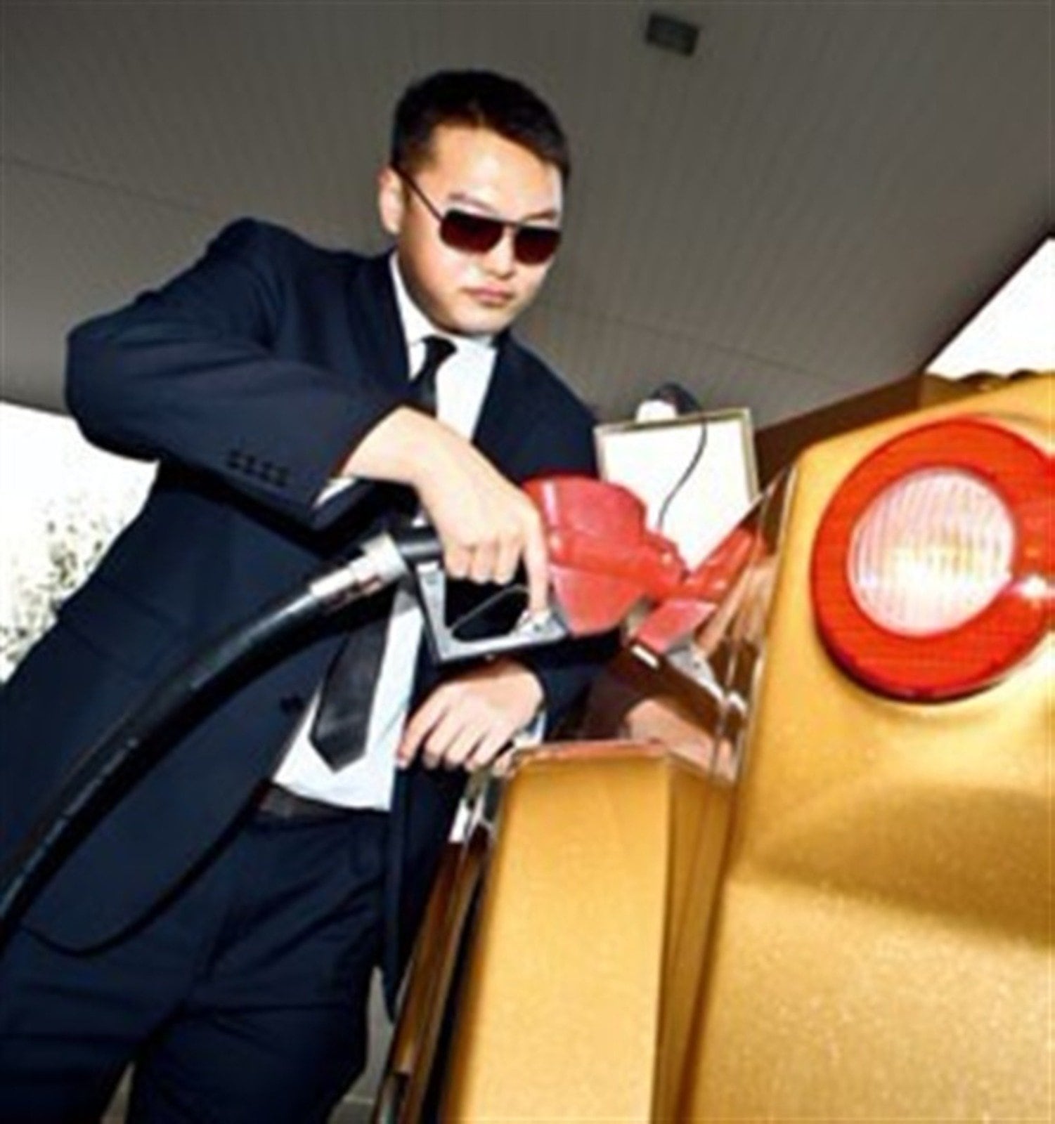 Chauffeur in sunglasses refuelling a gold DARTZ Prombron’