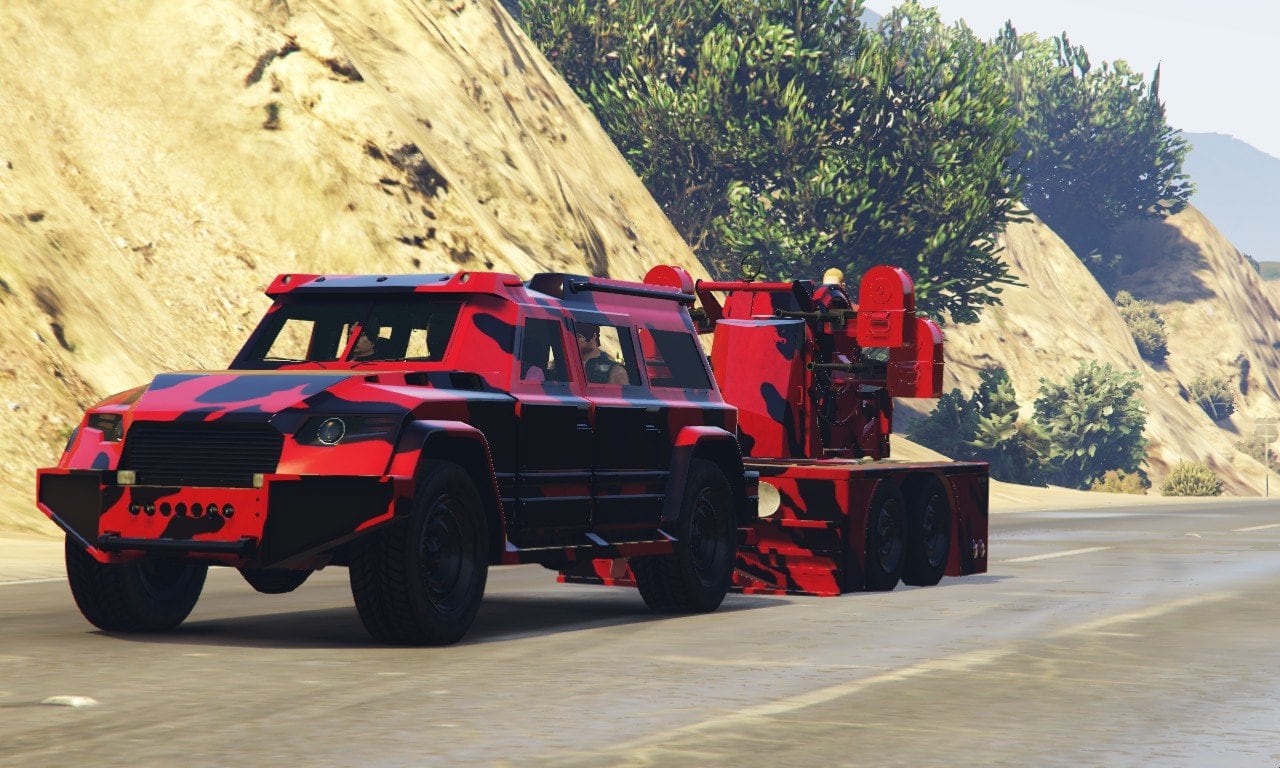 Red HVY Nightshark towing a trailer on a mountain road in GTA Online