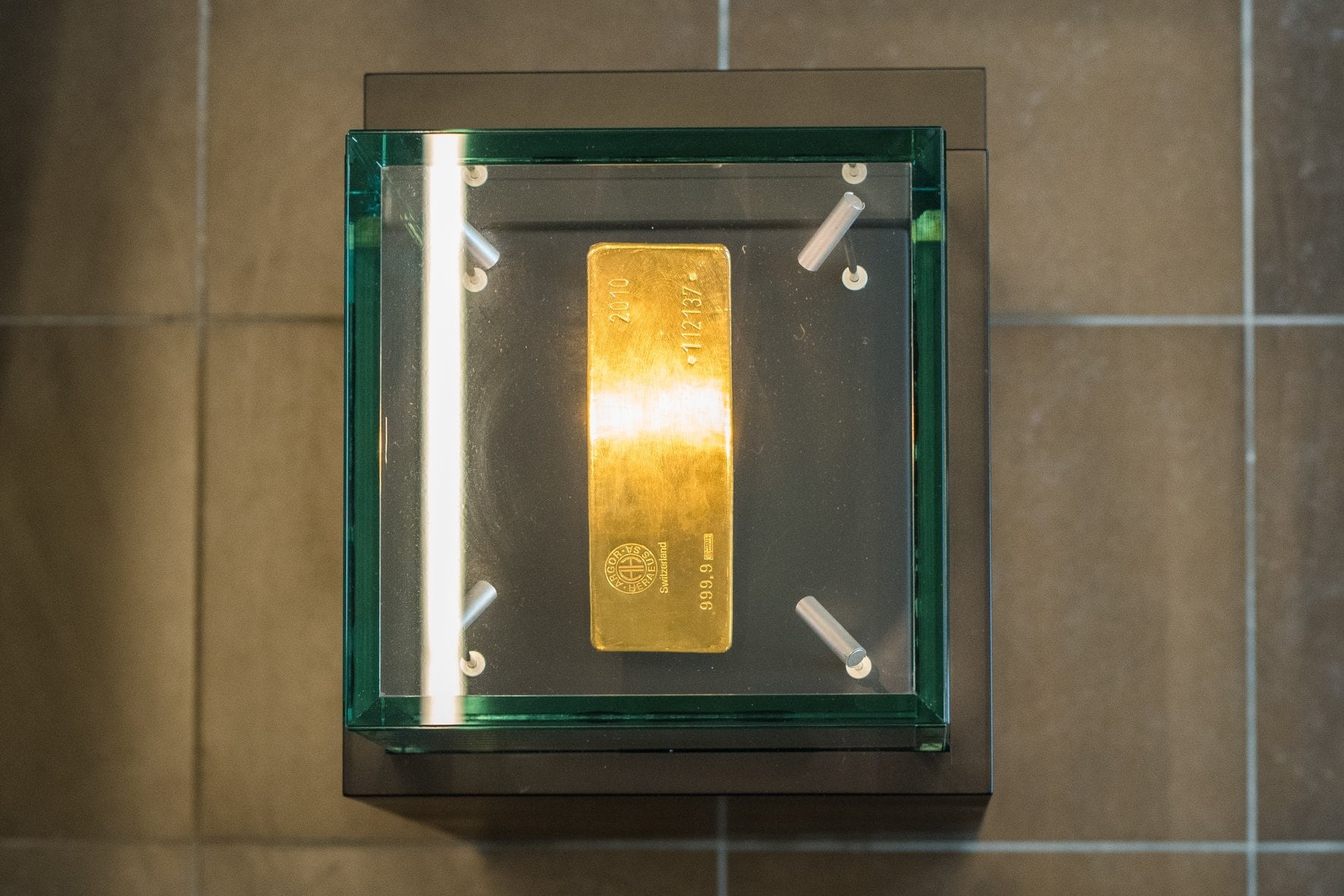 Gold bar mounted in a glass-fronted wall safe