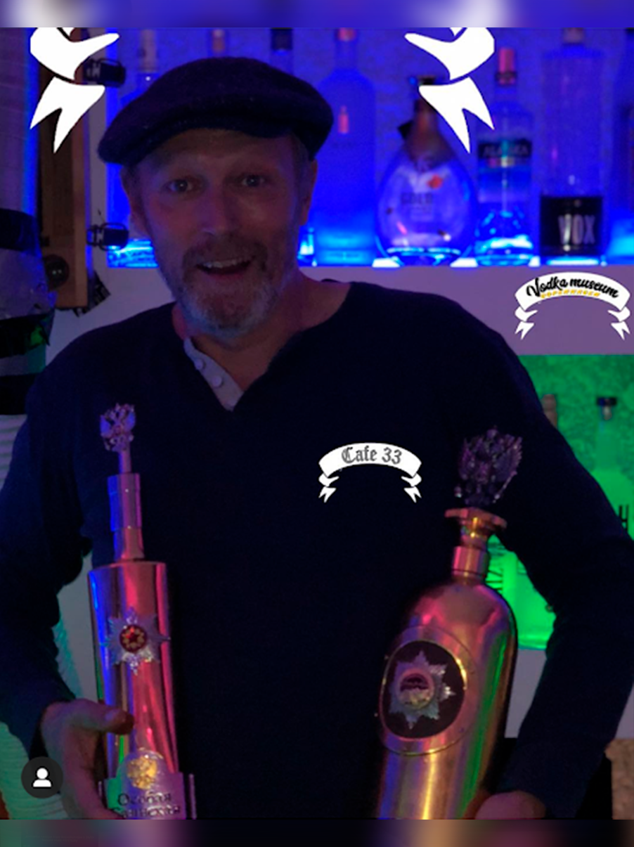 Man with two gold vodka bottles at Café 33, Copenhagen