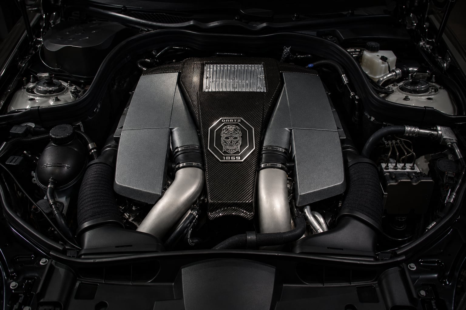 The twin-turbo V8 of the Black Shark under a carbon cover with the DARTZ skull crest