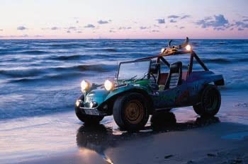 The DARTZ Golden Calf beach buggy at the water’s edge at dusk, its lamps lit