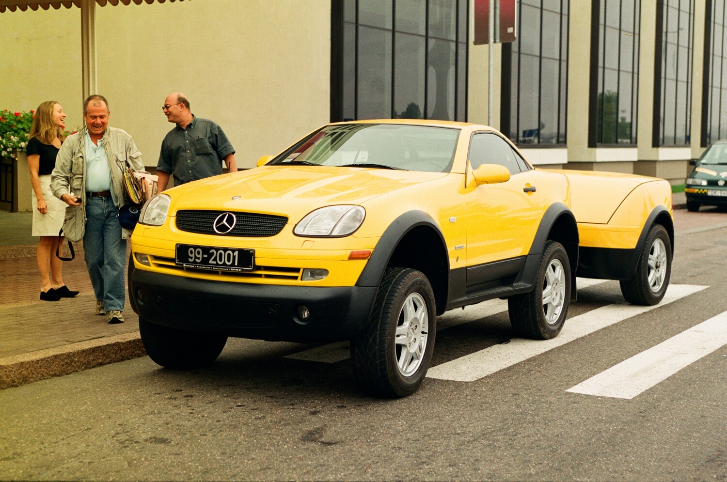 Leonard F. Yankelovich with Jim Rogers and Paige Parker beside the yellow Millennium Adventure Mercedes in Riga, 1999